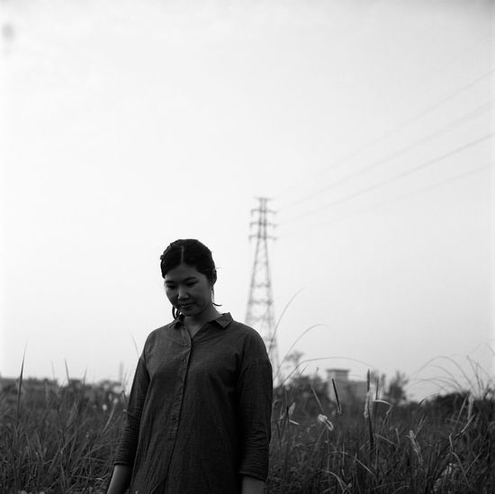 Woman standing on field against sky