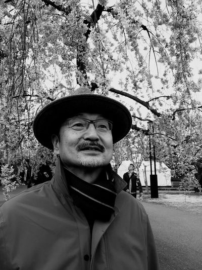 Portrait of man wearing hat against trees