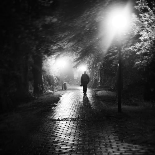 Woman walking on road at night