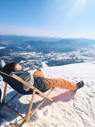 Woman relaxing on snow covered mountain