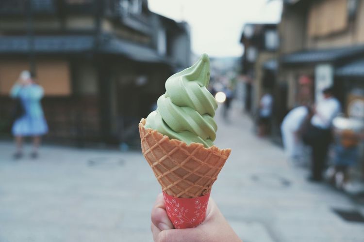 Cropped image of person holding ice cream outdoors