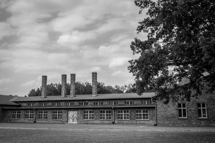 Old building by field against sky