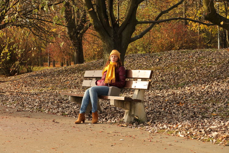 Full length portrait of woman sitting in park