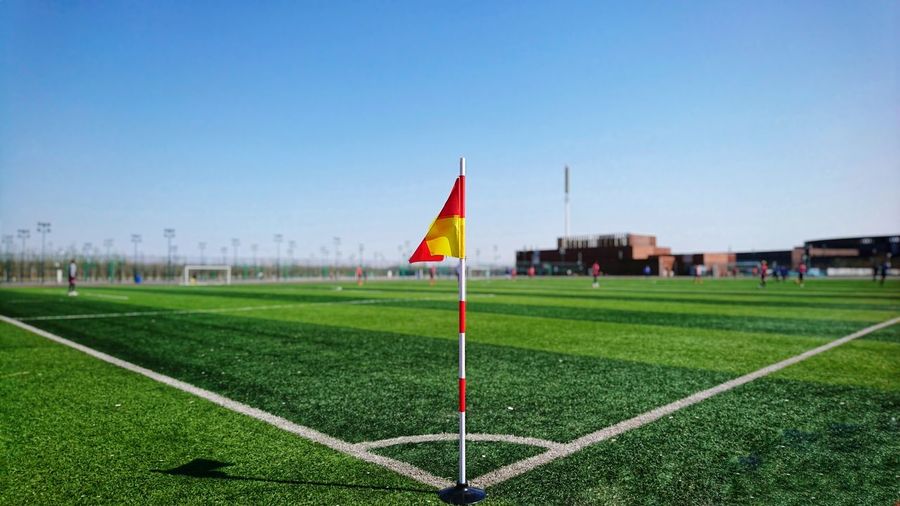 Flag on soccer field against clear sky