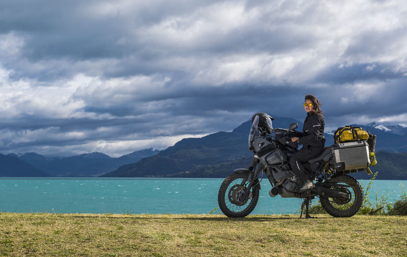 Woman sitting on enduro touring motorbike at lago rio tranquillo