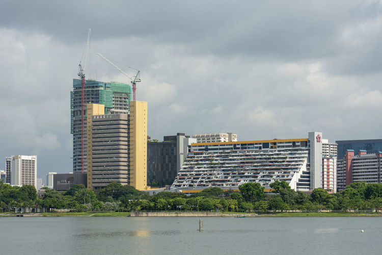 Buildings at waterfront in city against sky