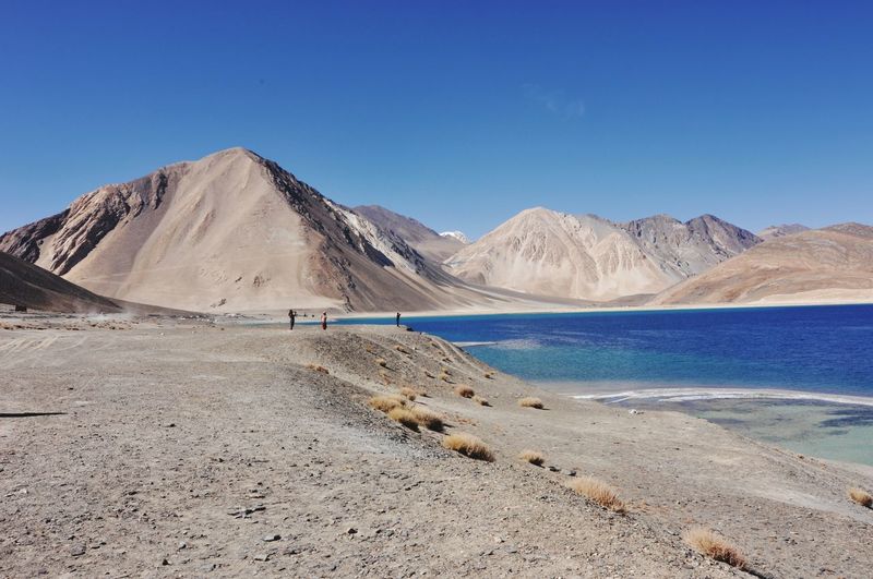 Scenic view of mountains against clear blue sky