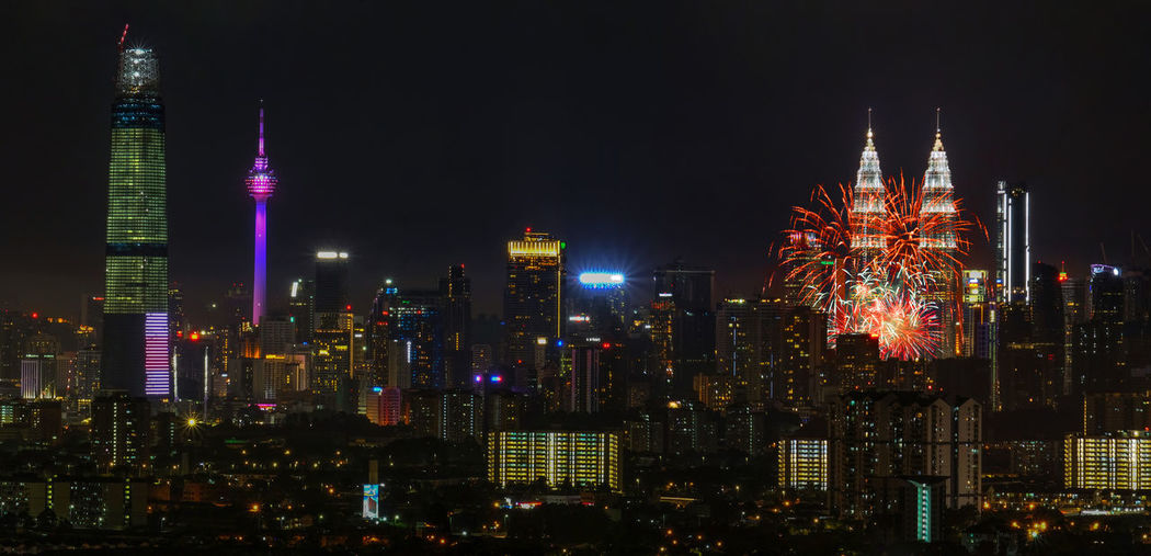 Firework display over illuminated in city at night