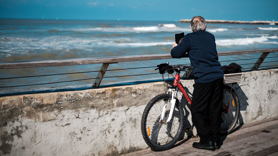 Man riding bicycle by sea