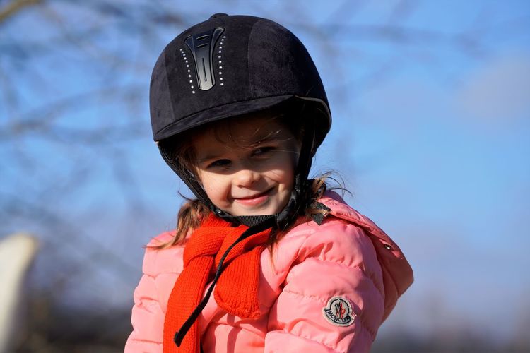Portrait of young smiling girl wearied in dressage helmet