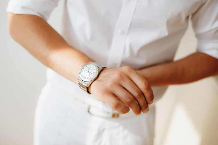 Midsection of man wearing wristwatch