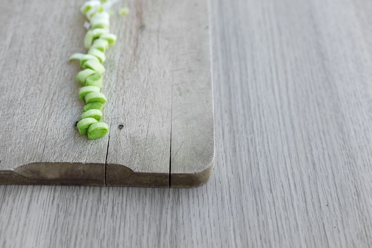 Close-up of spring onions on chopping board