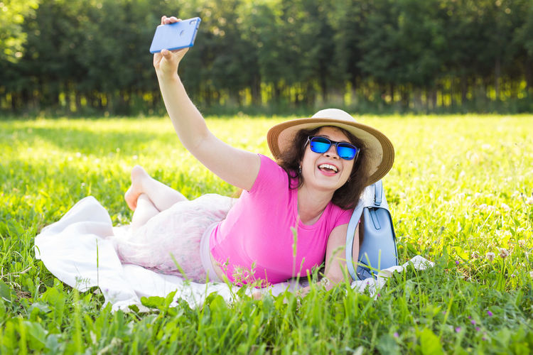 Portrait of smiling woman lying on grassy field