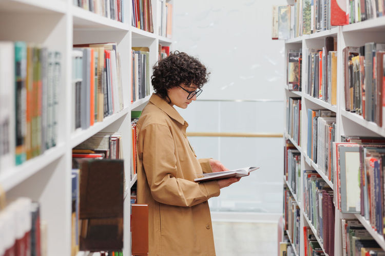 Side view of man standing in library