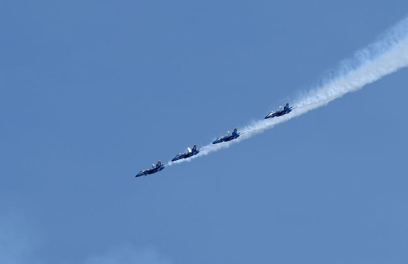 Low angle view of airshow flying against sky