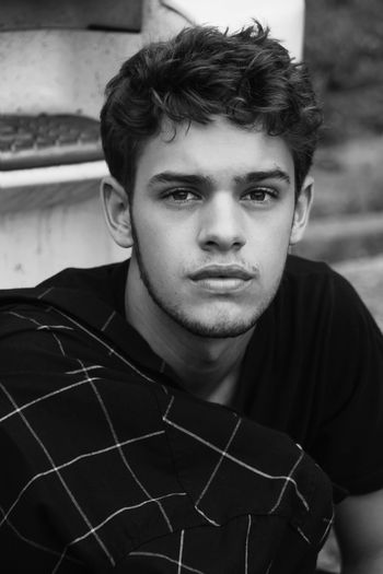 Portrait of young man sitting at park