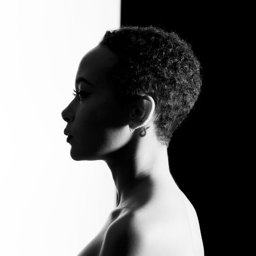 Side view of topless young woman against black and white background