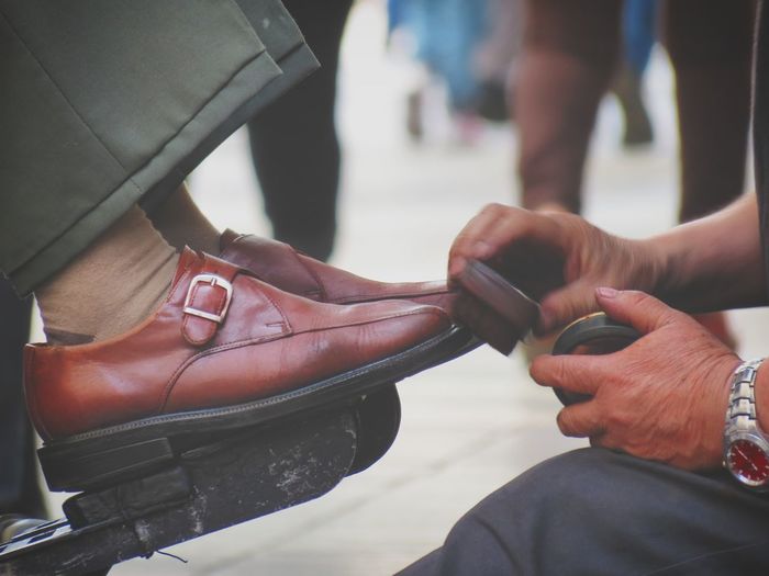 Close-up of man shining shoes outdoors