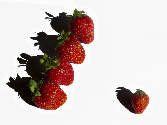 Close-up of strawberries on table against white background