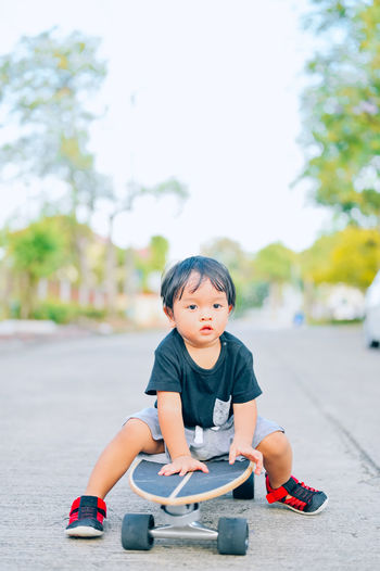 Cute boy sitting in toy car