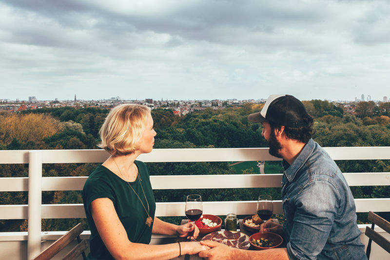 Couple having food and drink against sky