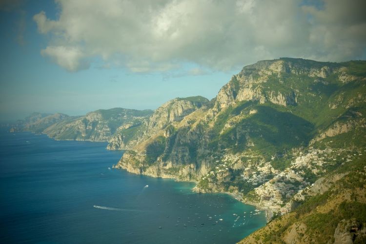 Scenic view of sea and mountains against sky