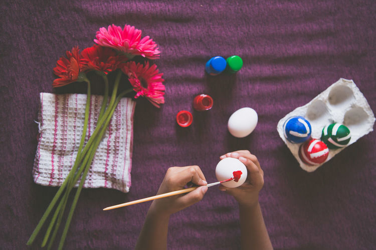 Directly above shot of person holding multi colored umbrella on table