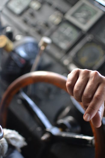 Cropped image of hand on steering wheel in boat