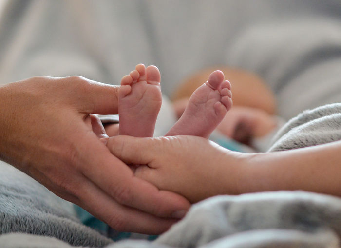 Father and mother hold baby feet in hands