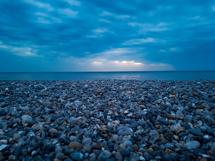 View of pebbles on beach against sky