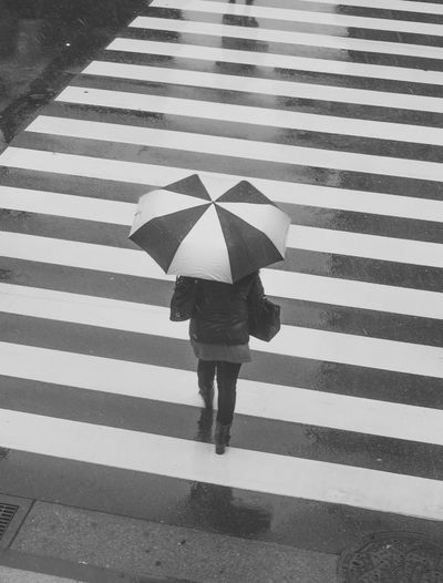 Low section of woman walking on street during rainy season