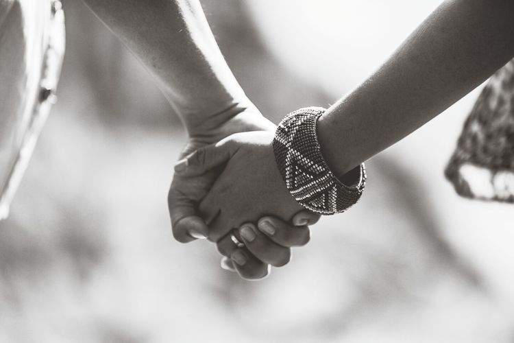 Close-up of hand holding hands against blurred background