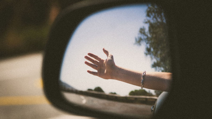 Close-up of hand on car window
