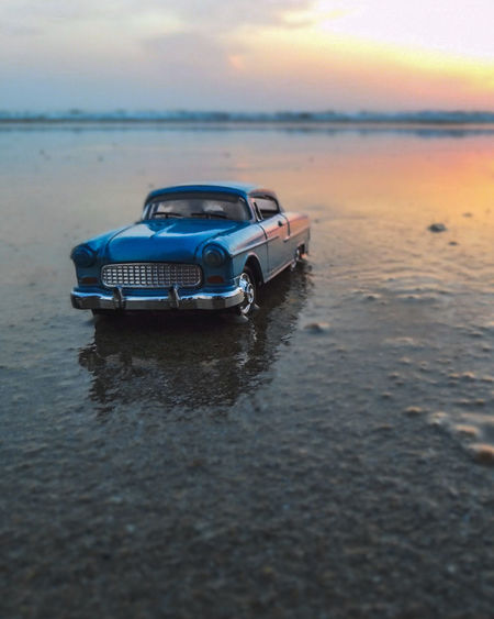 Boat on sea shore during sunset