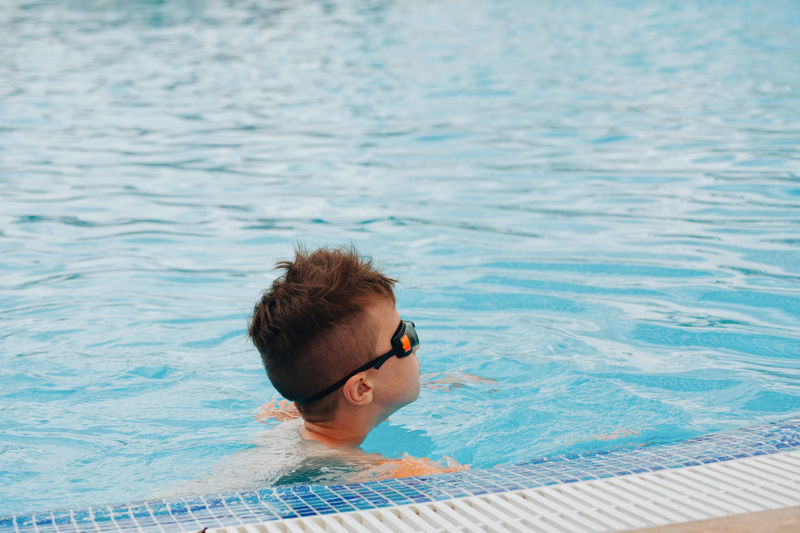 Side view of boy swimming in pool
