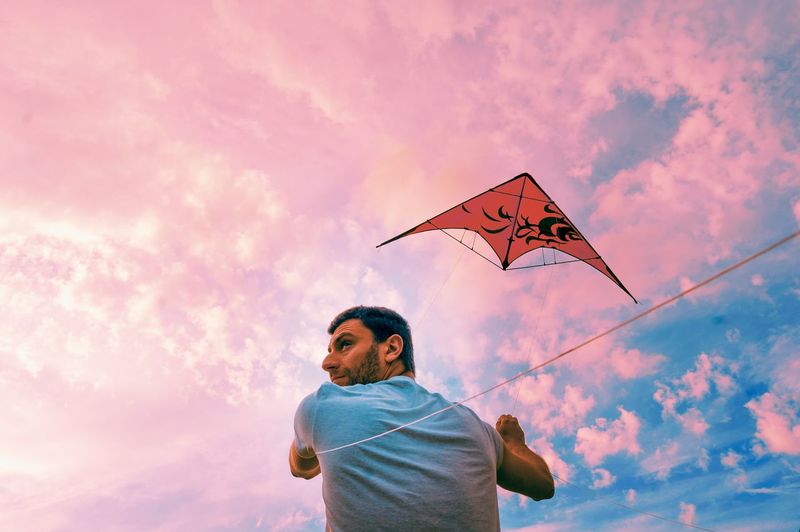 Low angle view of man standing against sky during sunset