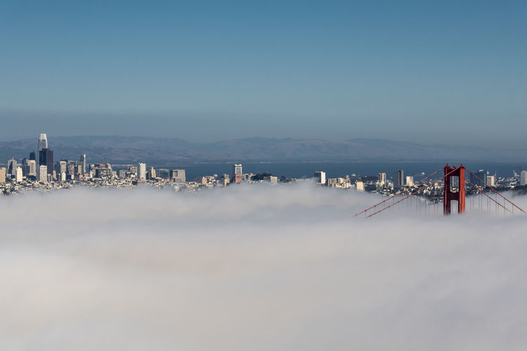 Golden gate under a blanket of fog and skyline of san francisco 