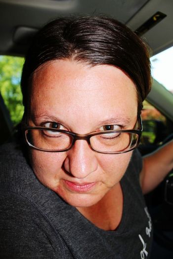 Portrait of serious woman wearing eyeglasses traveling in car