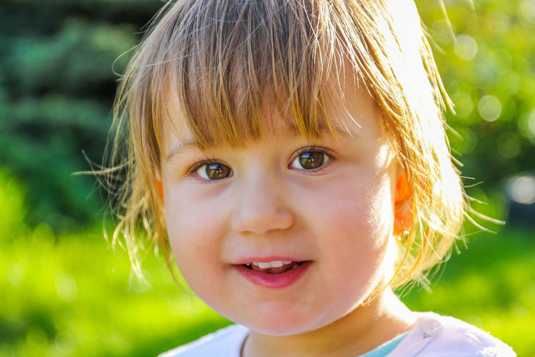 Close-up portrait of cute smiling girl in park