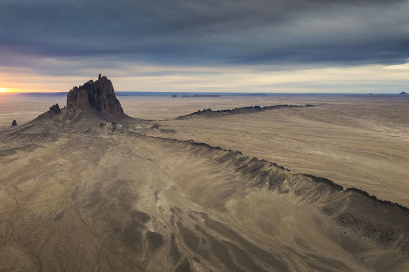 Panoramic view of shiprock, nm against sky during sunrise