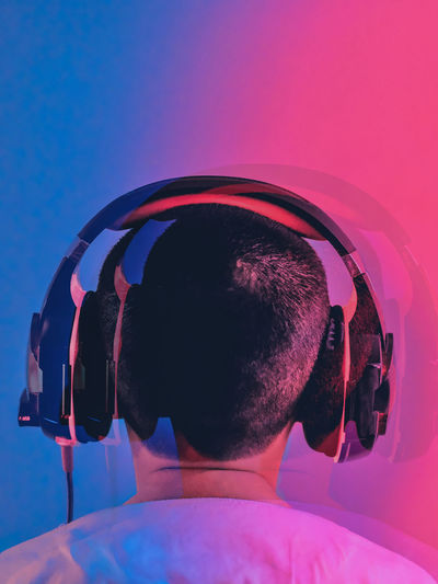 A boy listening to techno music against blue and red background