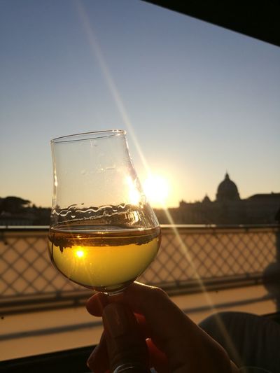 Man holding glass of sunset