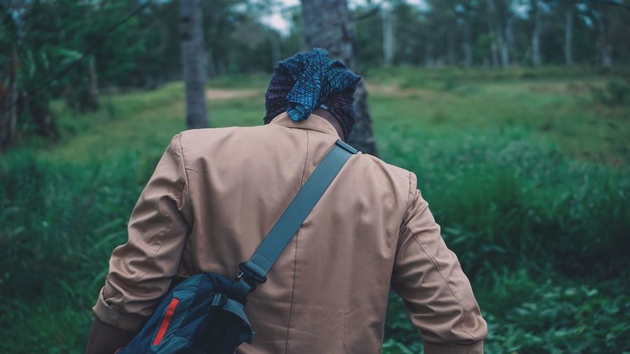 Rear view of man walking on field