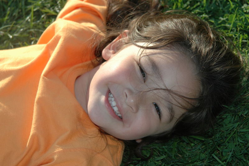 Close-up of smiling girl lying on field