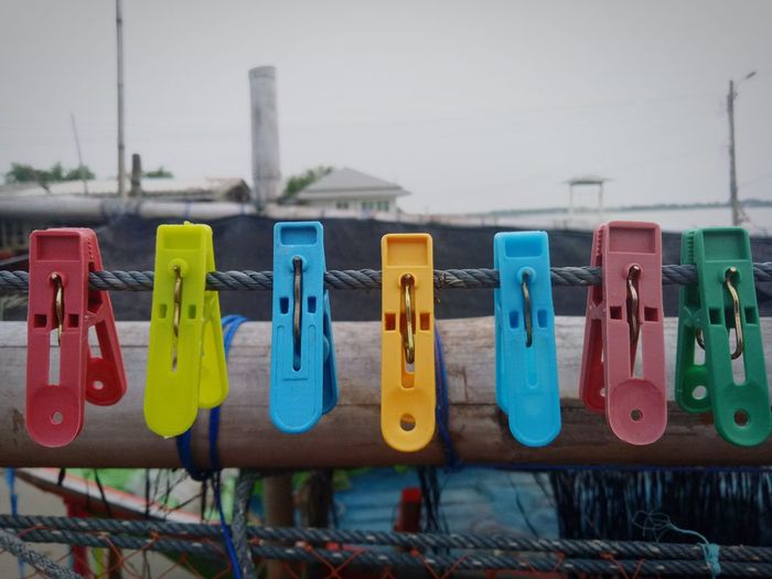 Close-up of multi colored clothespins hanging on clothesline