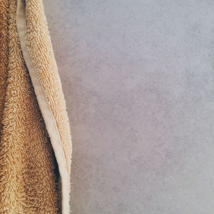 Cropped image of towel hanging on wall at home