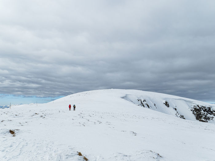 Two mountain hiker climbers walking on a snowy winter mountain ridge in tatra mountains slovakia