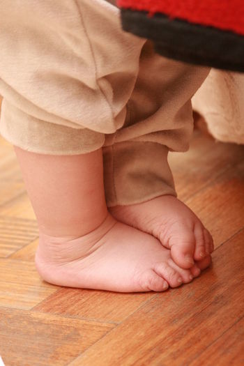Low section of baby feet on floor
