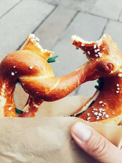 Close-up of hand holding pretzel