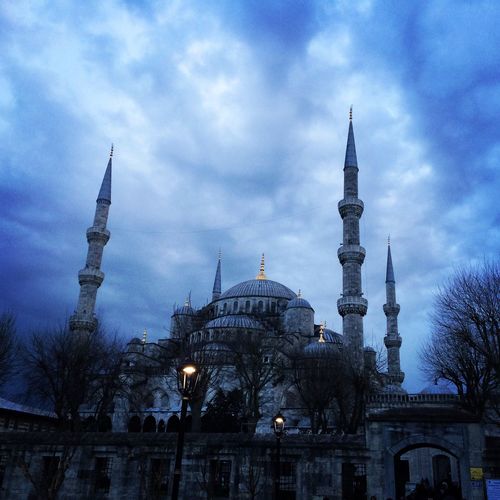 Low angle view of blue mosque against cloudy sky at dusk